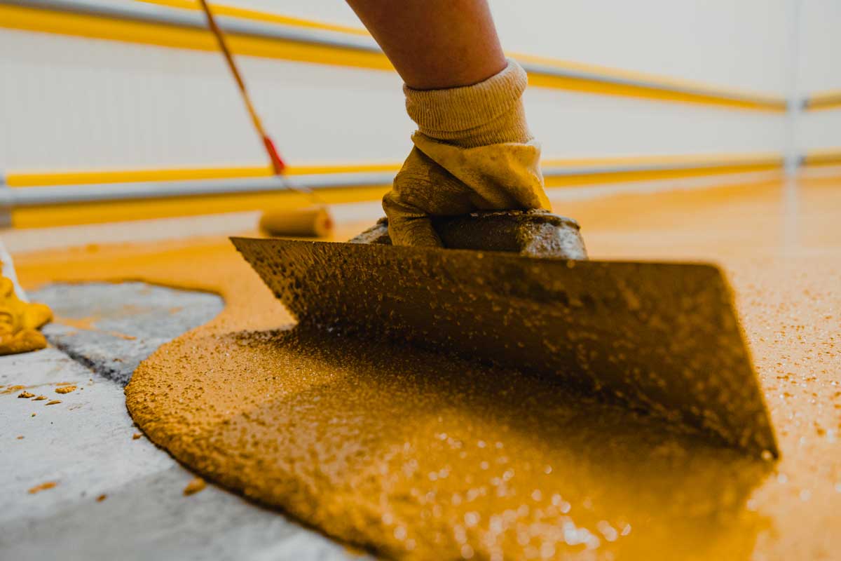 Worker Spreading Epoxy Floor Coating for Industrial Application